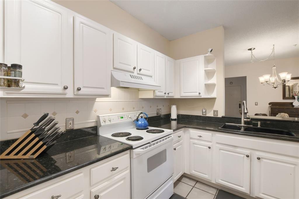 955 Juniper Street Northeast, Unit 4324 Atlanta, GA 30309 - Photo 9 of 26 a kitchen with granite countertop white cabinets and white appliances