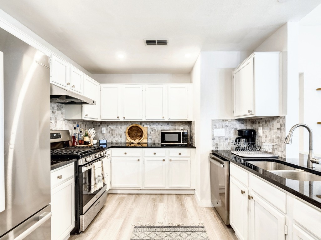 a kitchen with a sink a stove and cabinets