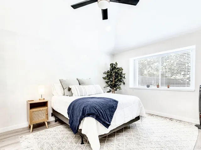 a bedroom with a bed lamp and a window