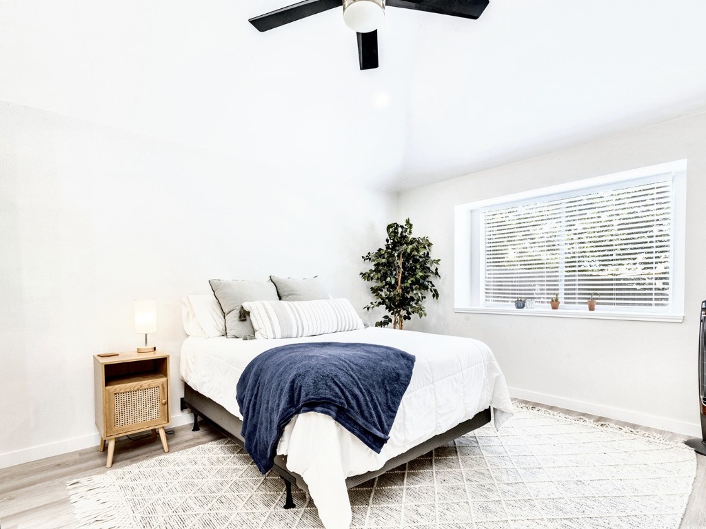 14205 Vandever Street Austin, TX 78725 - Photo 11 of 23 a bedroom with a bed lamp and a window