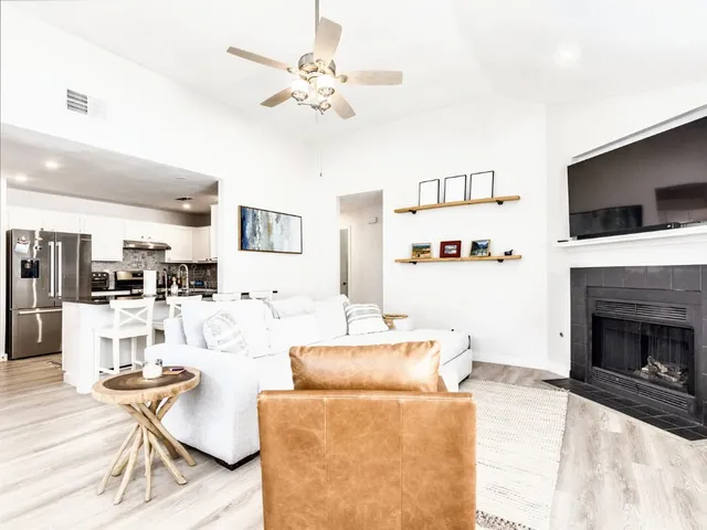 a living room with furniture a flat screen tv and kitchen view