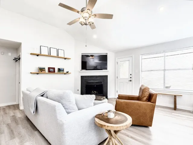 a living room with furniture a fireplace and a flat screen tv