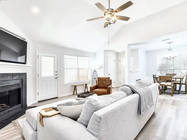 a living room with furniture a fireplace and a flat screen tv