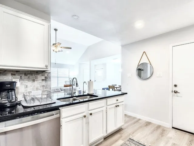 a spacious bathroom with a granite countertop sink and a mirror
