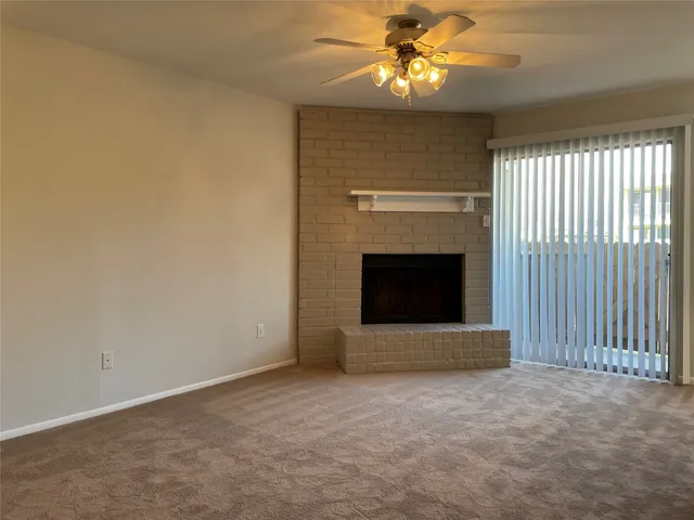 an empty room with a fireplace and fan