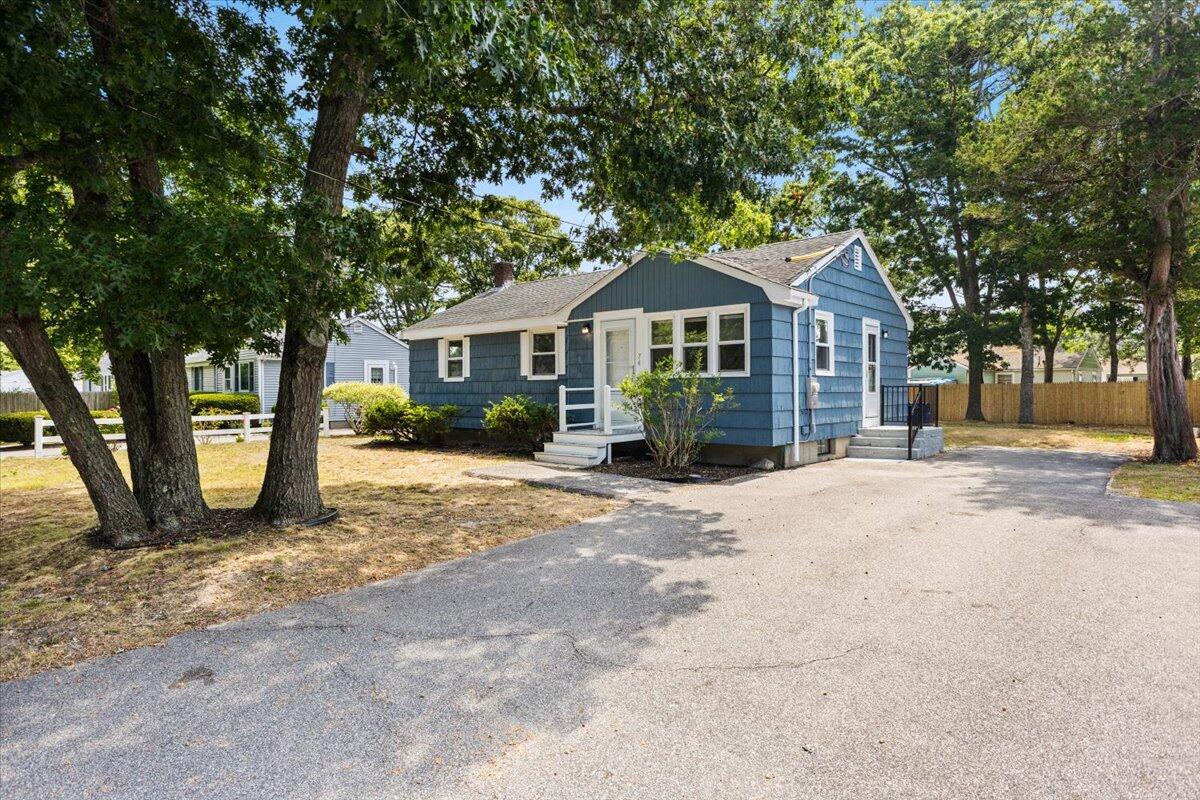 74 Fearing Street Buzzards Bay, MA 02532 - Photo 4 of 32 a front view of a house with a yard and large trees