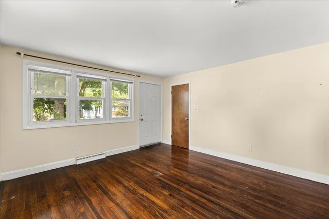 a view of a room with wooden floor and window
