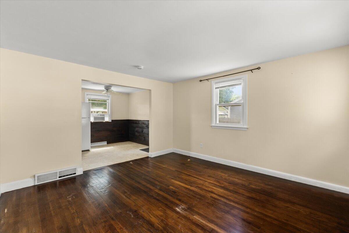 74 Fearing Street Buzzards Bay, MA 02532 - Photo 10 of 32 a view of an empty room with wooden floor and a window