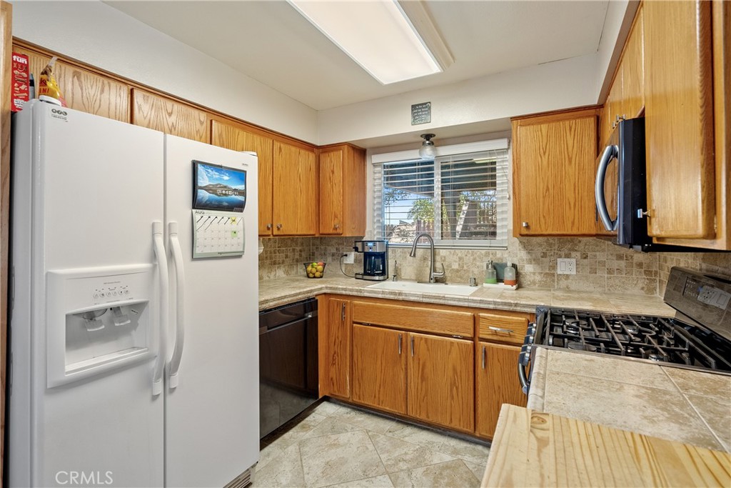 1747 Brighton Avenue Grover Beach, CA 93433 - Photo 9 of 50 a kitchen with stainless steel appliances a refrigerator sink and cabinets
