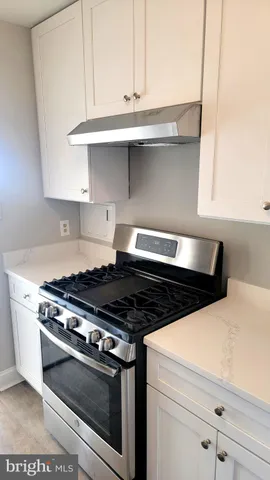 a stove top oven sitting inside of a kitchen