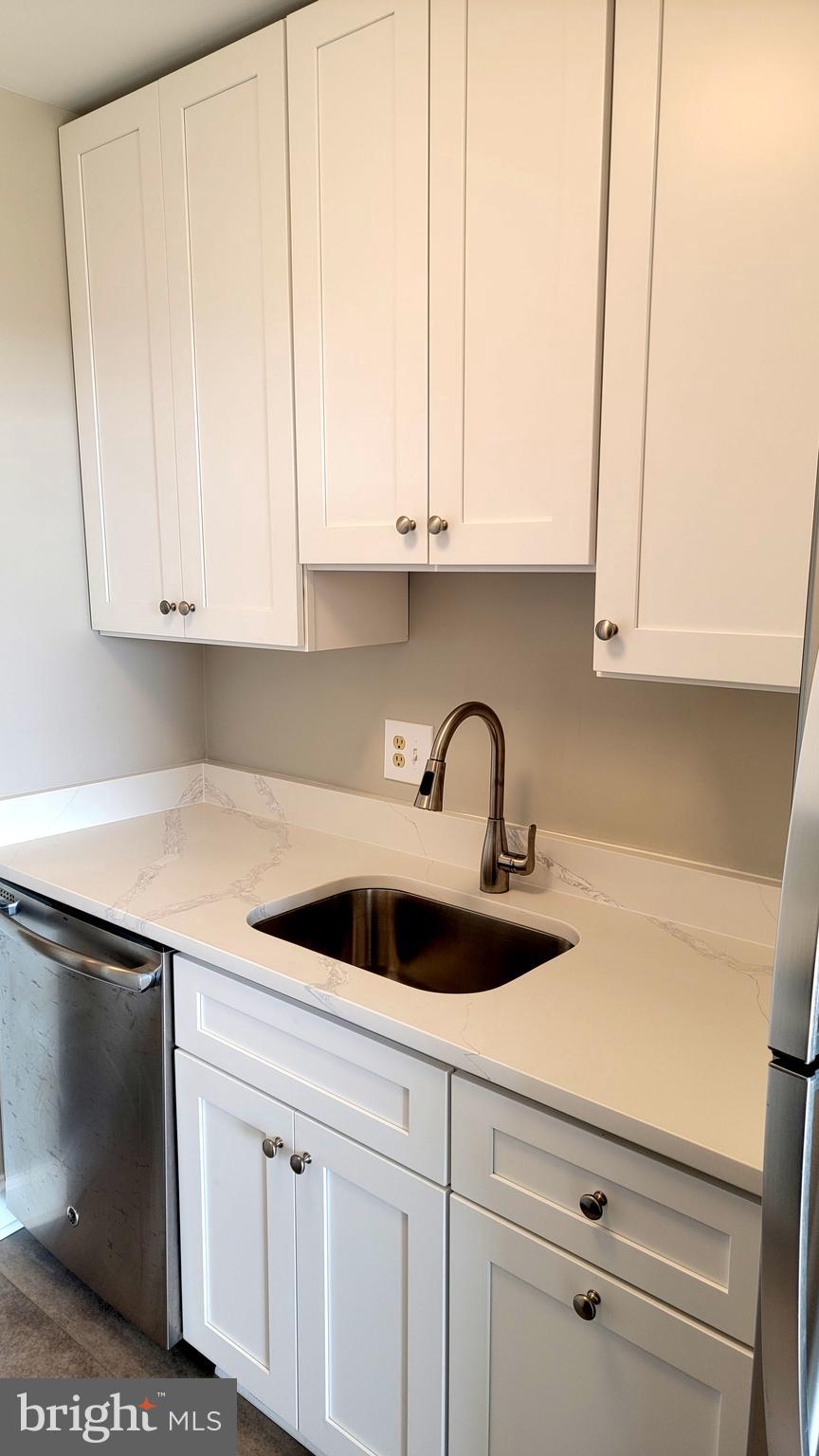 301 North Beauregard Street, Unit 903 Alexandria, VA 22312 - Photo 4 of 19 a kitchen with white cabinets and a sink