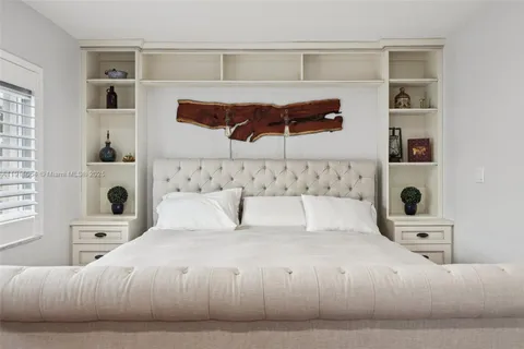 a bedroom with a bed a dresser and wooden floor