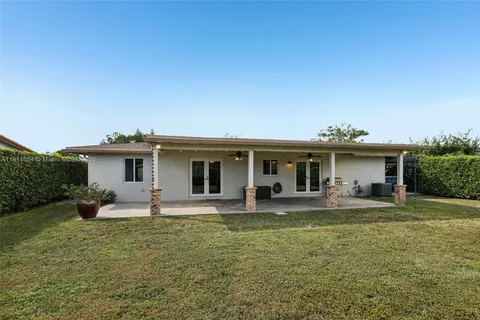 an aerial view of residential houses with outdoor space and trees