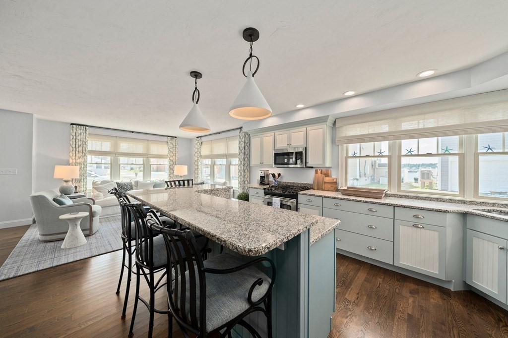 77 Lighthouse Road Scituate, MA 02066 - Photo 12 of 42 a kitchen with granite countertop a table chairs stove and white cabinets