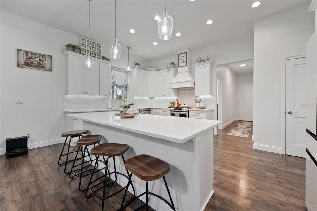 3262 Pheasant Trail Mims, FL 32754 - Photo 44 of 79 a kitchen with kitchen island a stove a table and chairs in it