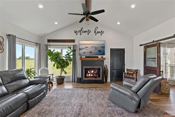 a living room with furniture a large window and a fireplace