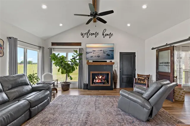 a living room with furniture a large window and a fireplace