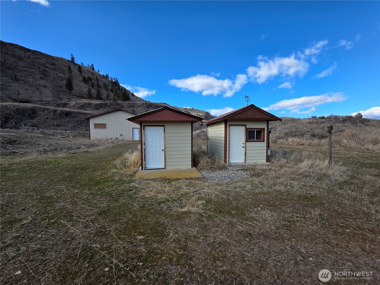 105 Emily Road Oroville, WA 98844 - Photo 4 of 24 a view of a house with a backyard