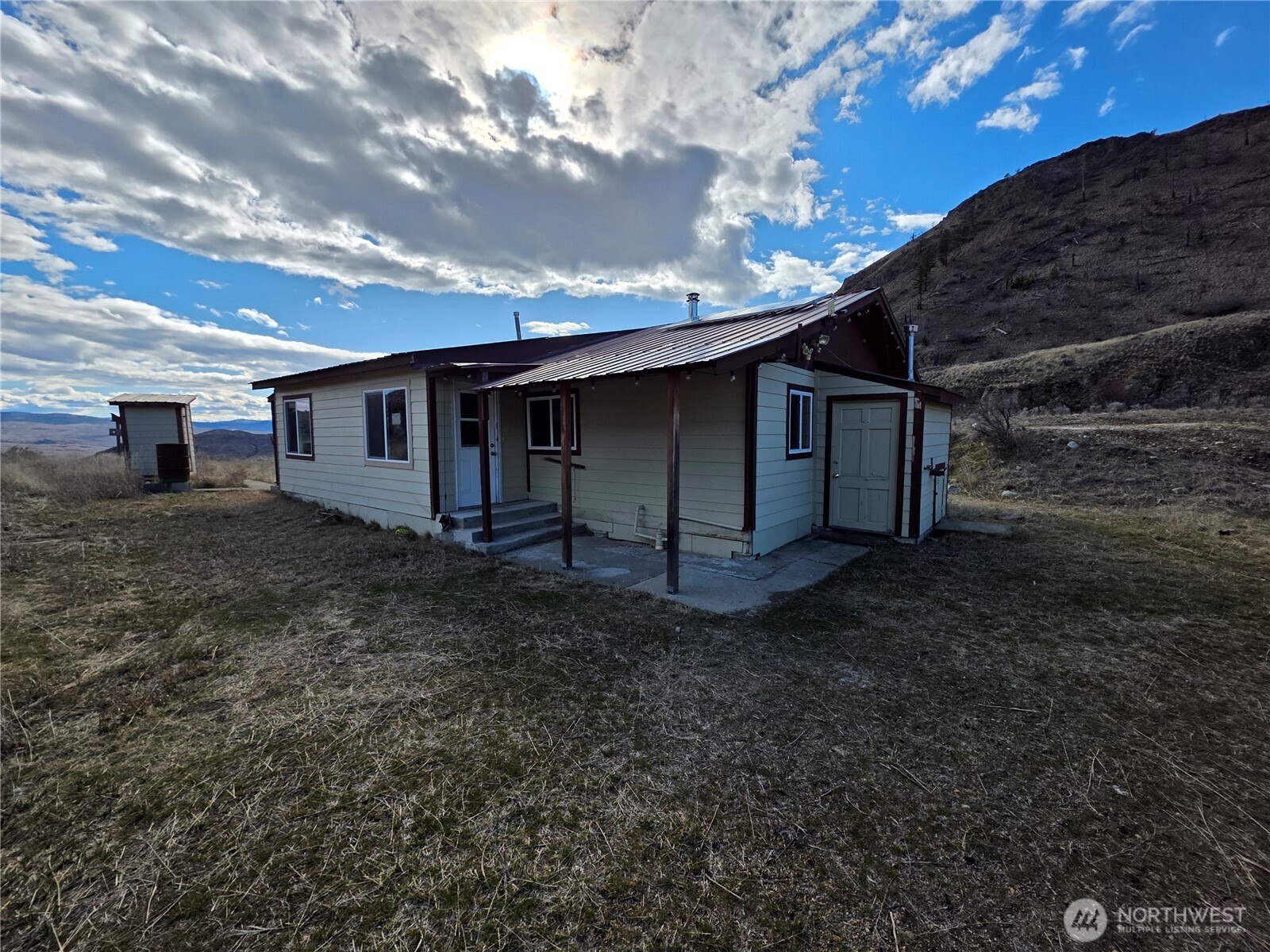 105 Emily Road Oroville, WA 98844 - Photo 5 of 24 a view of a house with a backyard