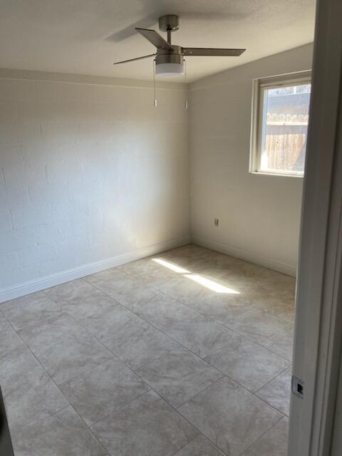2326 East Hampton Way Fresno, CA 93726 - Photo 2 of 6 an empty room with windows and fan