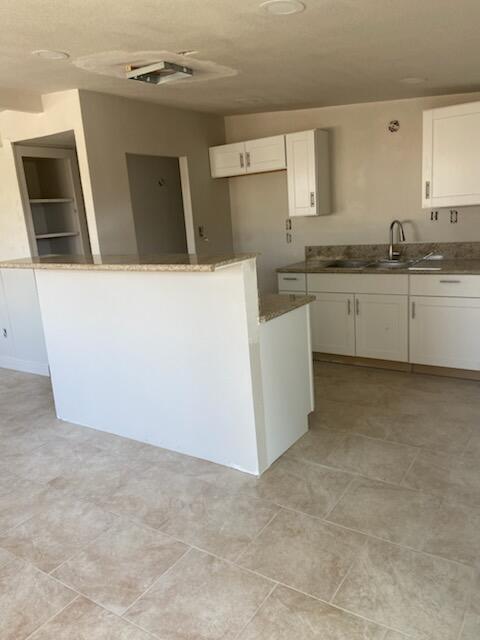 2326 East Hampton Way Fresno, CA 93726 - Photo 5 of 6 a kitchen with granite countertop a refrigerator a stove a microwave and cabinets
