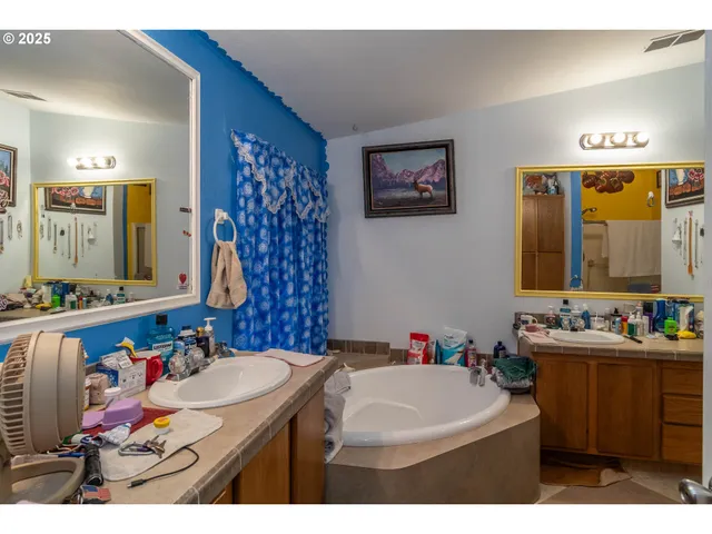 a bathroom with a sink vanity tub and a mirror