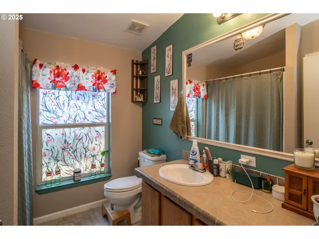 a bathroom with a sink vanity mirror and toilet
