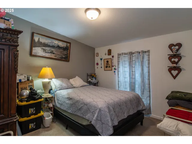 a bedroom with a bed and dresser with mirror