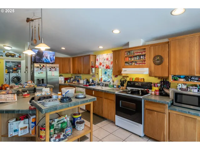 a kitchen with stainless steel appliances granite countertop a stove top oven a sink dishwasher and cabinets with wooden floor