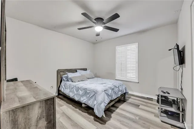 a bedroom with a bed and a ceiling fan