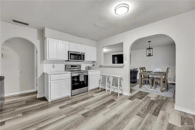 a kitchen with white cabinets and stainless steel appliances