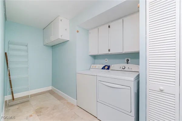 a utility room with cabinets washer and dryer