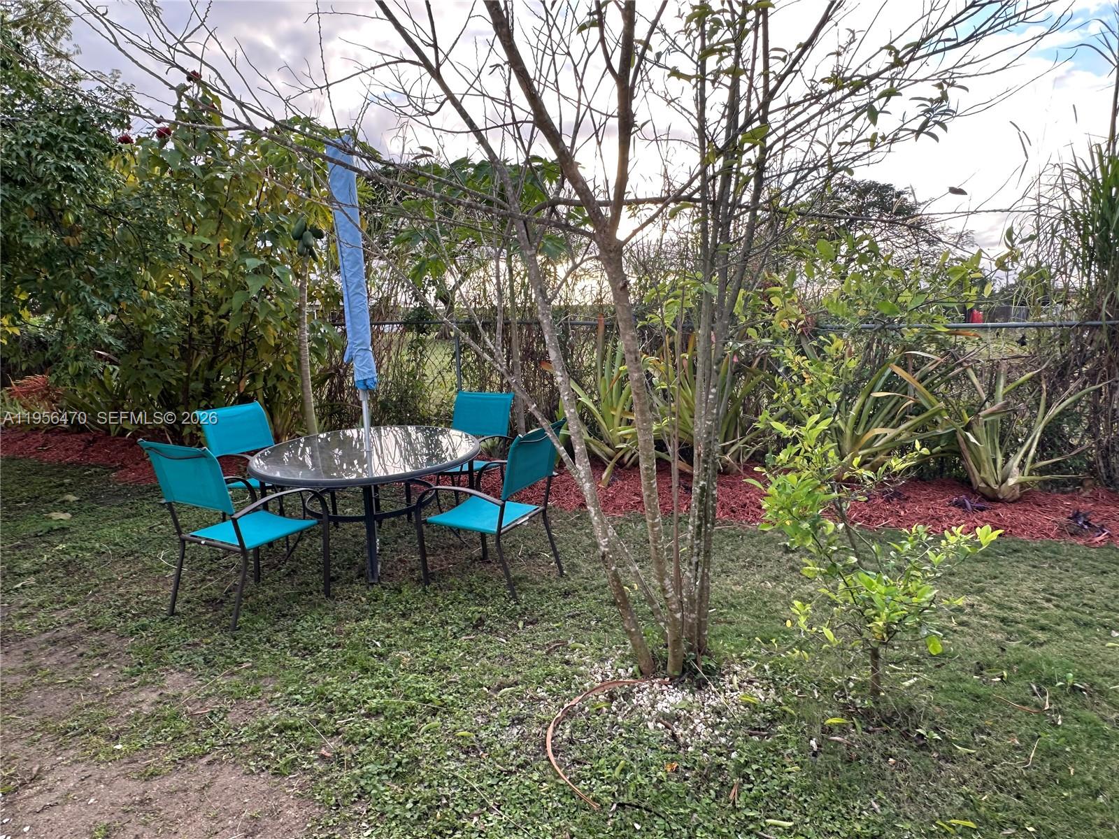 18481 Southwest 208th Street, Unit 18481 Miami, FL 33187 - Photo 11 of 12 a view of a table and chairs in the garden
