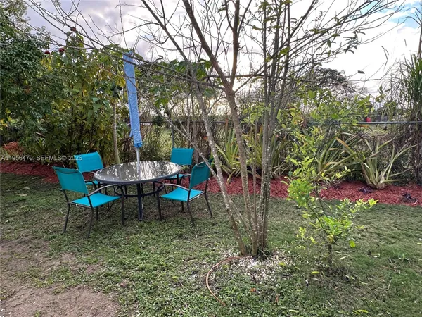 a backyard of a house with table and chairs