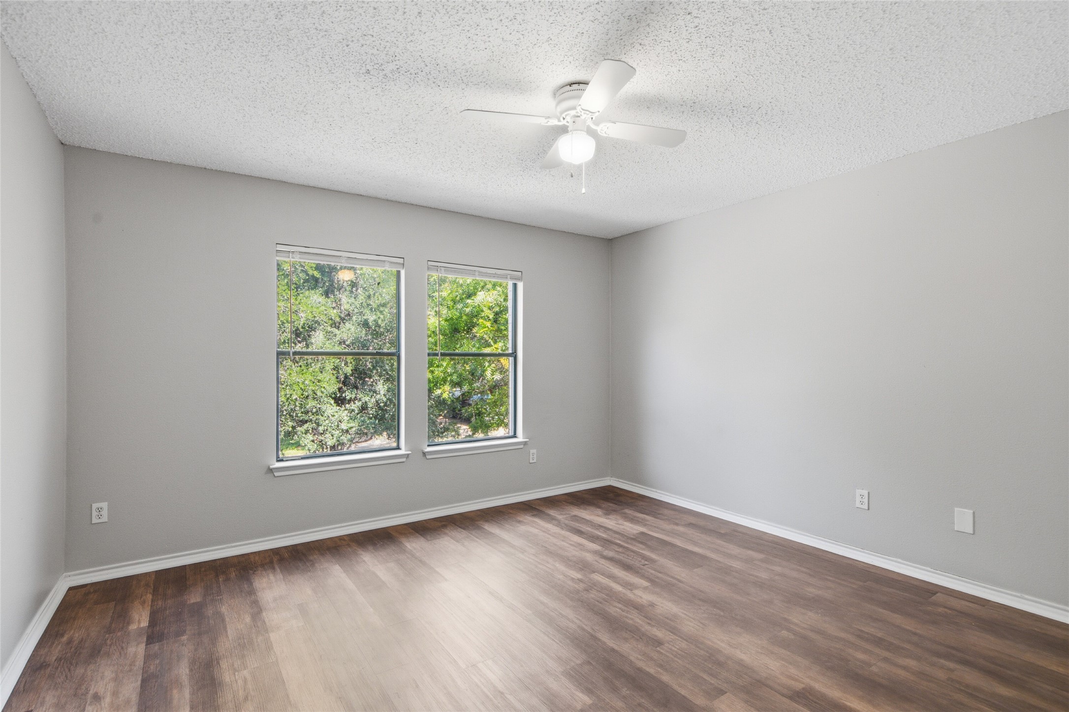 7900 Rosenberry Drive Austin, TX 78747 - Photo 14 of 27 Well-lit room features rich wood flooring and a ceiling fan for comfort.