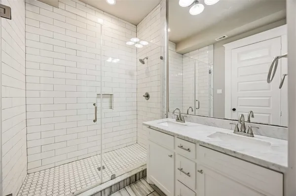 a bathroom with a shower sink and mirror