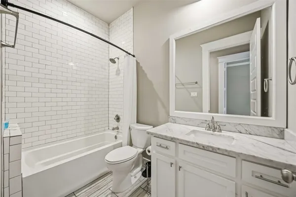 a bathroom with a granite countertop toilet a sink and bathtub