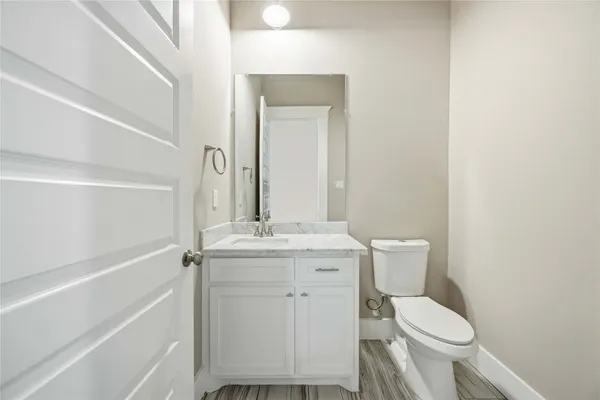 a bathroom with a granite countertop toilet sink and mirror