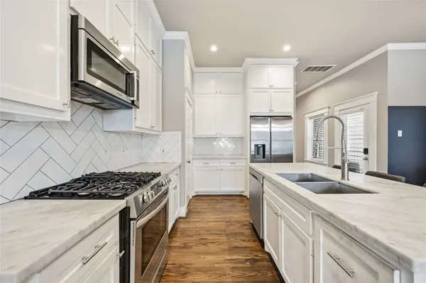 a kitchen with stainless steel appliances granite countertop a sink stove and refrigerator