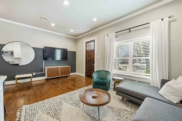 a living room with furniture a window and a flat screen tv