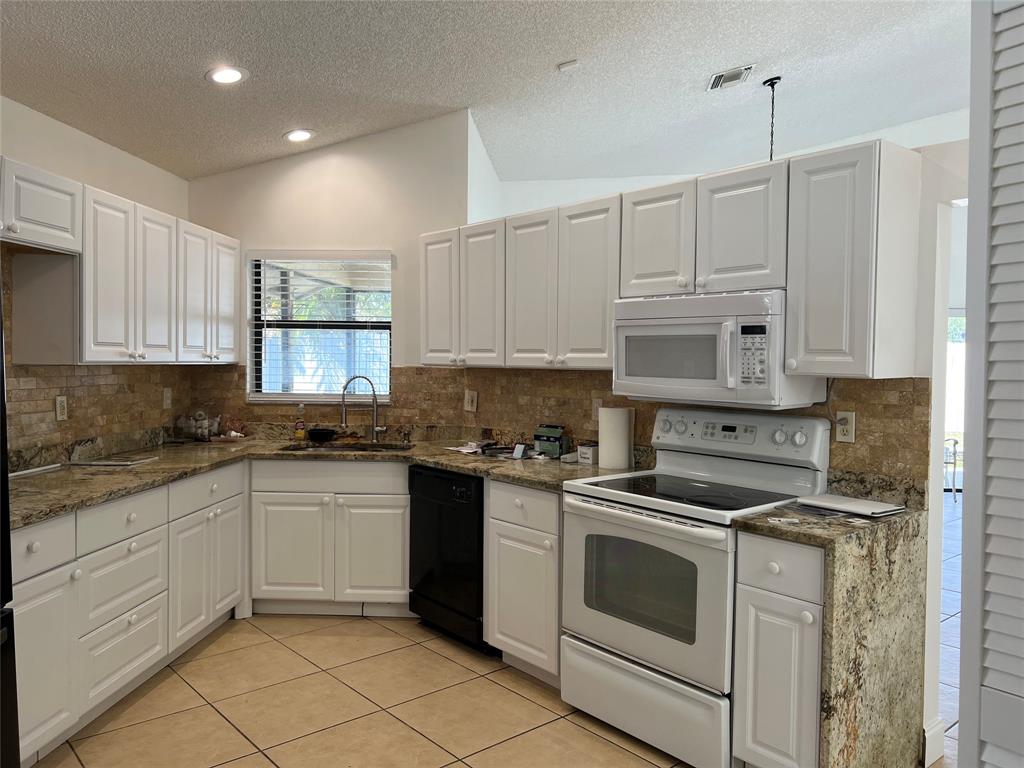 371 Mohawk Lane Boca Raton, FL 33487 - Photo 6 of 26 a kitchen with cabinets appliances a sink and a counter top space