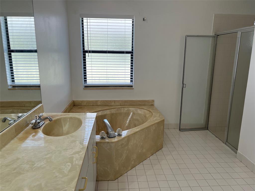 371 Mohawk Lane Boca Raton, FL 33487 - Photo 8 of 26 a bath tub sitting in a bathroom next to a window
