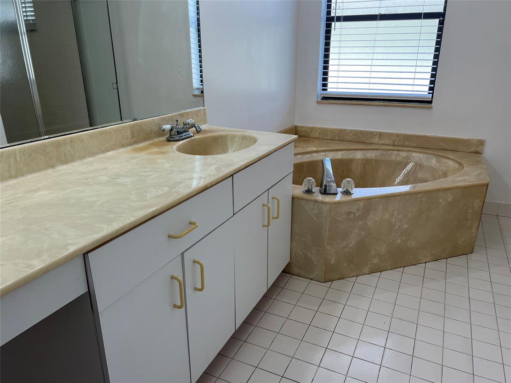 371 Mohawk Lane Boca Raton, FL 33487 - Photo 9 of 26 a bath tub sitting in a bathroom next to a sink