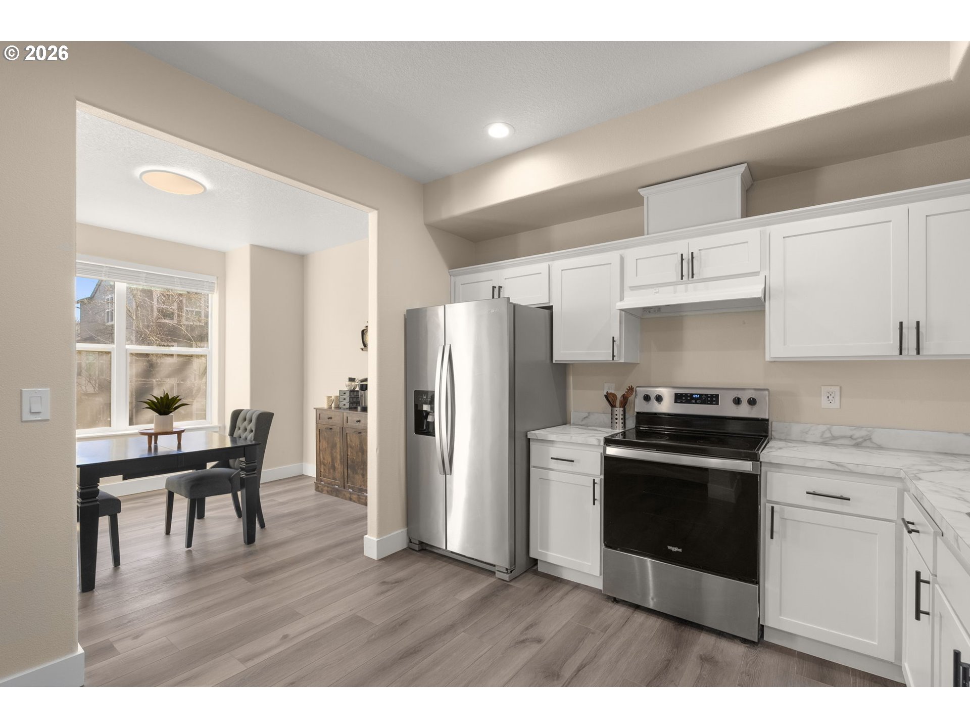 13193 Southwest Raptor Place Tigard, OR 97223 - Photo 6 of 27 a kitchen with stainless steel appliances wooden floors and wooden cabinets