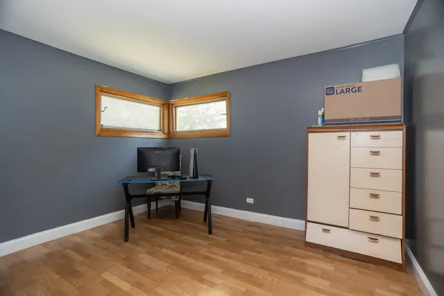 a view of a workspace with furniture and a window