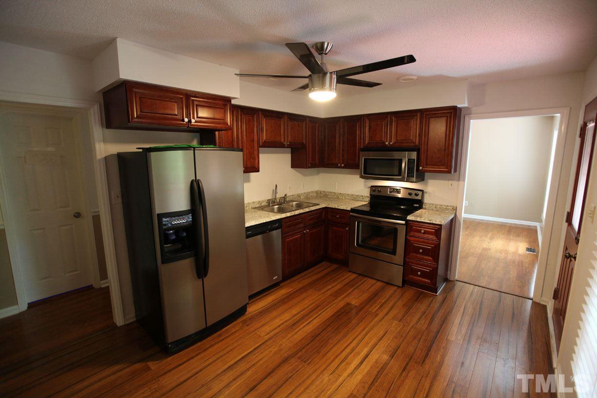 7319 Post Oak Road Raleigh, NC 27615 - Photo 2 of 12 a kitchen with stainless steel appliances granite countertop a refrigerator a sink dishwasher a stove and a refrigerator with wooden floor