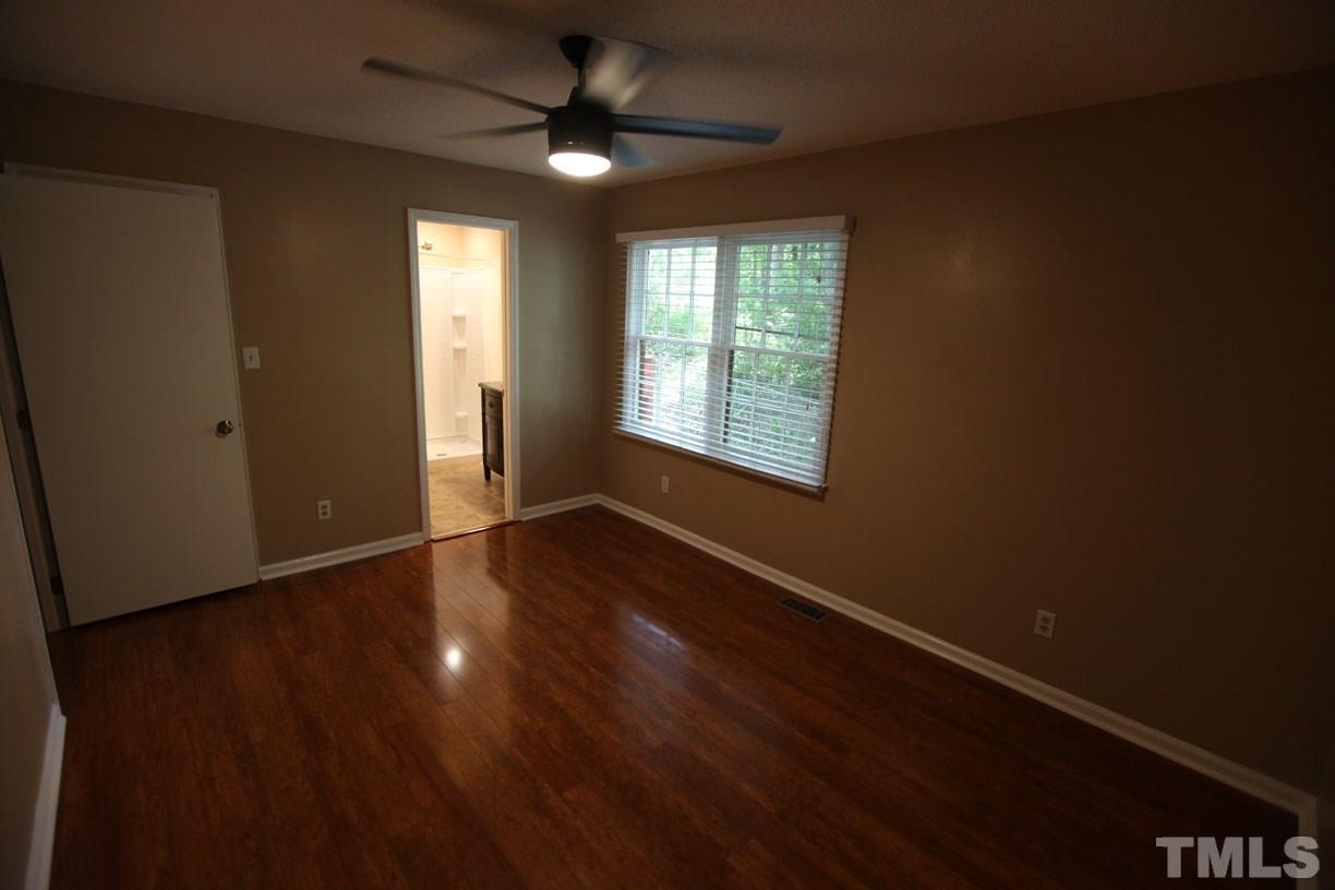 7319 Post Oak Road Raleigh, NC 27615 - Photo 5 of 12 an empty room with wooden floor fan and windows