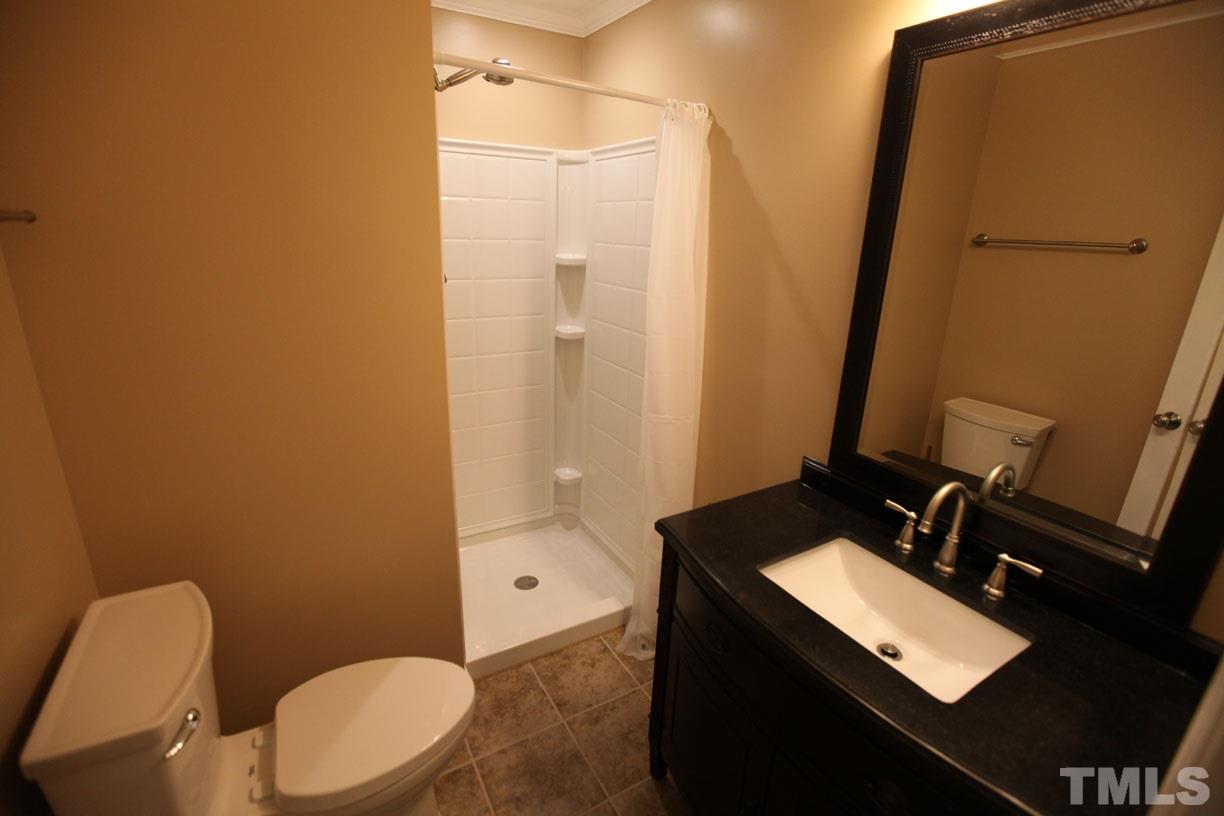 7319 Post Oak Road Raleigh, NC 27615 - Photo 6 of 12 a bathroom with a toilet a sink and mirror