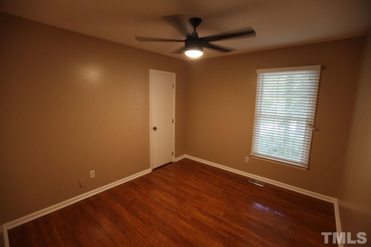 7319 Post Oak Road Raleigh, NC 27615 - Photo 7 of 12 an empty room with a window and a ceiling fan
