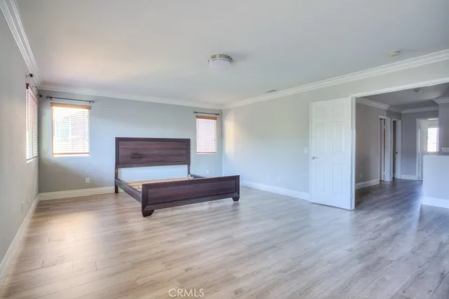 a view of a hallway with wooden floor and a bathroom